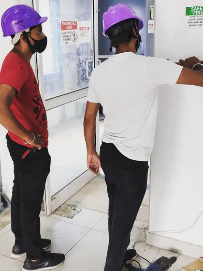 Our team works together on-site to plan and execute the installation. Here, our technicians are preparing the entry point for a new access control unit, ensuring all wiring and placement is optimized for performance and aesthetics.