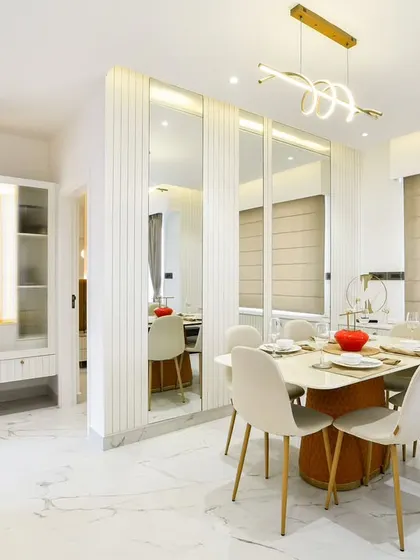 The dining area is perfectly integrated with the living space, featuring clean lines, a modern dining set, and ample storage in the form of sleek, mirrored cabinetry.