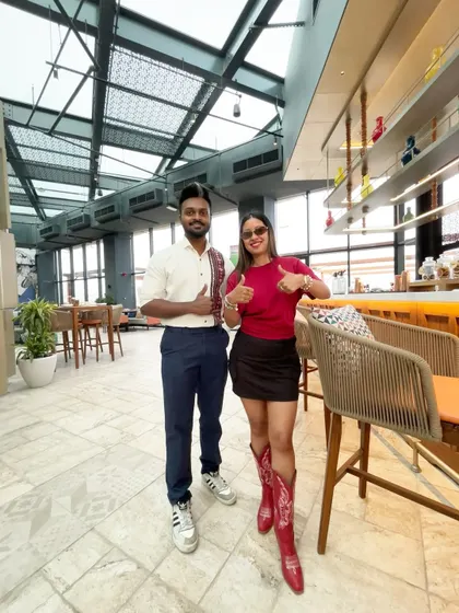 Giving a thumbs-up with a team member inside the stylish lounge area of the hotel.