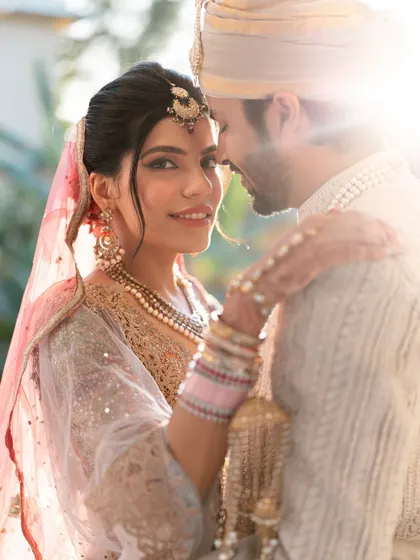 A sun-kissed close-up of the couple, with the bride looking directly at the camera, creating a personal and engaging portrait.