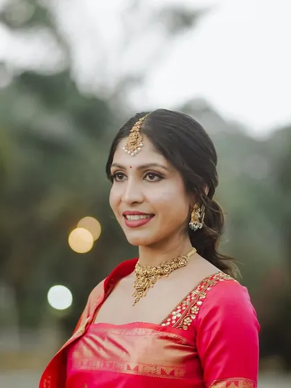 A close-up outdoor portrait. The soft light highlights her glowing skin.