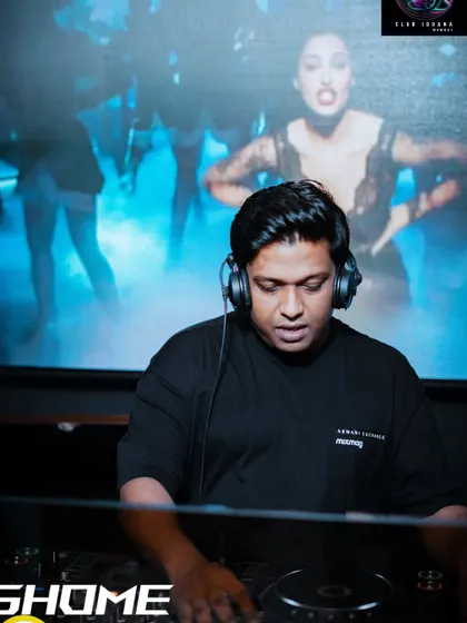 In the zone at Club Iguana. The background visuals and the blue lighting create a cool, focused atmosphere while I line up the next track.