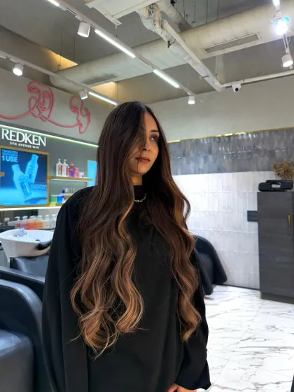 This long, flowing hair is brought to life with a vibrant balayage using Redken color. The lighter ends create a beautiful contrast and make the hair look incredibly healthy and full.