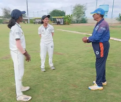 The head coach has a discussion with two of our women cricketers, offering personalized feedback and guidance.
