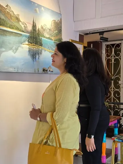 Visitors admiring a beautiful landscape painting. Our gallery is a serene and welcoming space for anyone looking to immerse themselves in art.