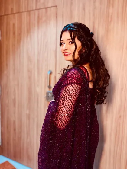 This bride is ready for her reception party. The look features a bold red lip, shimmery eyes, and beautiful cascading curls for a touch of glamour.