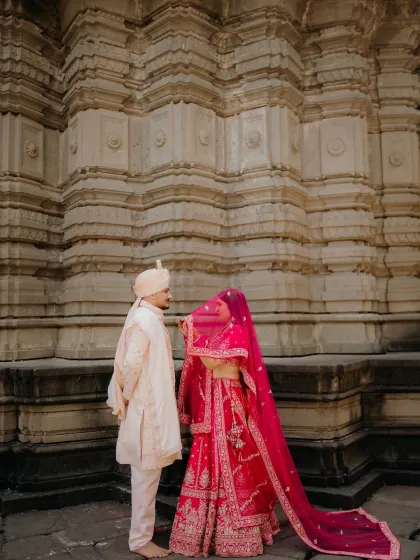 A playful and romantic 'peek-a-boo' moment with the bride's veil. This adds a touch of fun to the traditional wedding portraits.