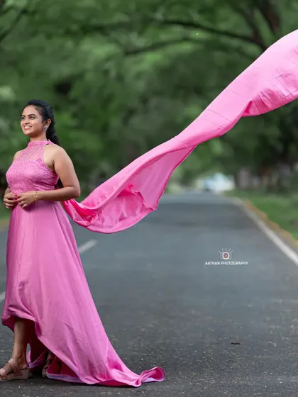 This pink rental gown features a beautiful high-neck textured top and a long, flowing trail that catches the wind perfectly for dynamic shots.