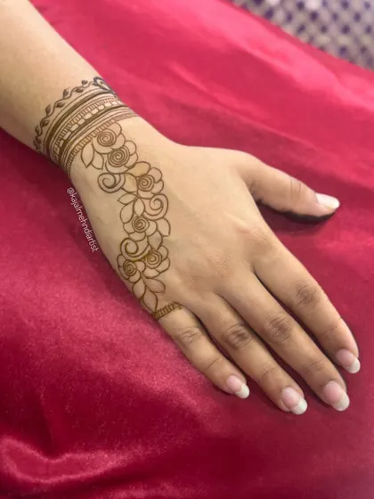 A simple and beautiful floral vine design. This is a perfect choice for guests who want something elegant and quick. The pattern gracefully flows down one side of the hand.