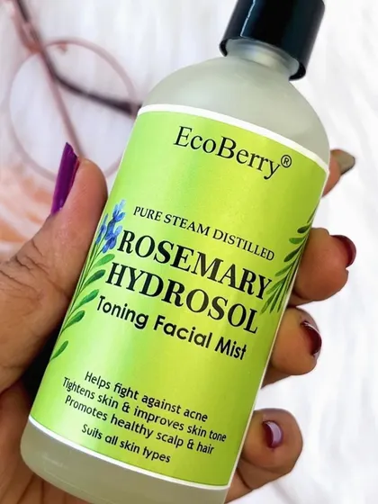A detailed shot of our Pure Steam Distilled Rosemary Hydrosol. The label clearly states its benefits: fights acne, tightens skin, improves tone, and promotes a healthy scalp and hair.