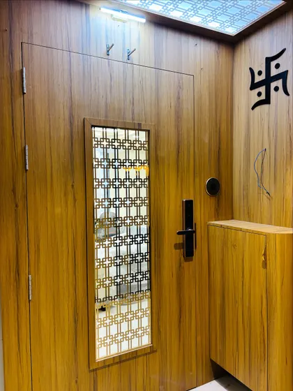 A view of the entrance foyer showing the safety door, a small storage cabinet, and a Swastik symbol for a traditional blessing.