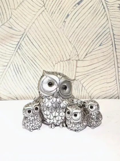 A sleek, silver-finished owl family figurine. This modern and elegant piece is perfect for a contemporary home.