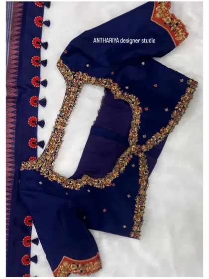 The back of the navy blue blouse features a stylish and intricate cutout design.