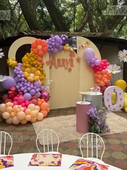 Another view of the floral and groovy-themed 10th birthday party. The setup includes giant daisy props and a colorful balloon arch, creating a fun and whimsical atmosphere.