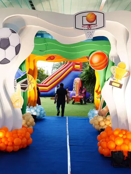 A fantastic custom-built entrance for a sports-themed party, complete with soccer ball, basketball hoop, and other athletic details.