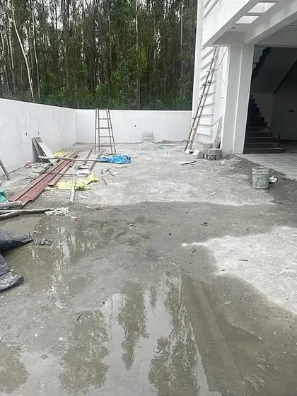 A messy construction site before my landscaping work begins. This area will be cleared and leveled to prepare for a new stone patio.