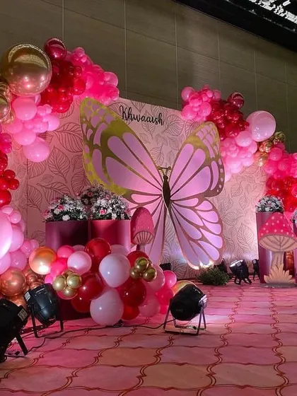 Another angle of the pink and red butterfly stage, showing the arrangement of props and the rich color combination.