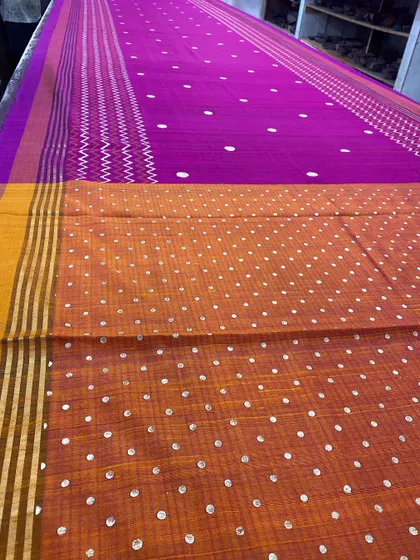 A magenta and orange silk saree after our block printing process. The tiny silver butis and the geometric patterns on the pallu add so much character.