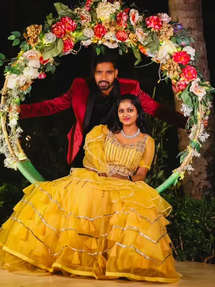 This couple looks picture-perfect on a floral swing, dressed in their coordinated yellow and red outfits.