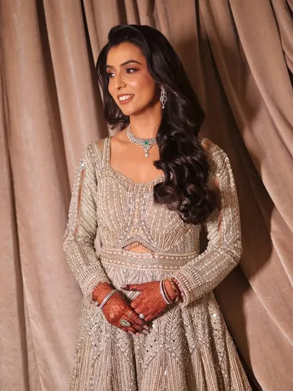 A full-length shot of the client in her shimmering reception gown, looking happy and confident.