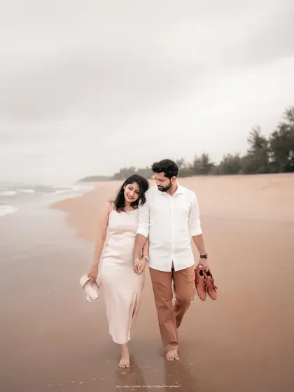 A romantic walk on Honnavara beach for a pre-wedding shoot. The couple's relaxed posture and the serene environment make for a beautiful memory.