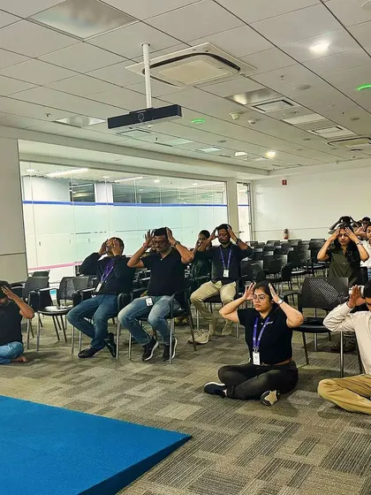 A group practicing Bhramari Pranayama (Bee Breath) during a corporate meditation session to calm the mind.