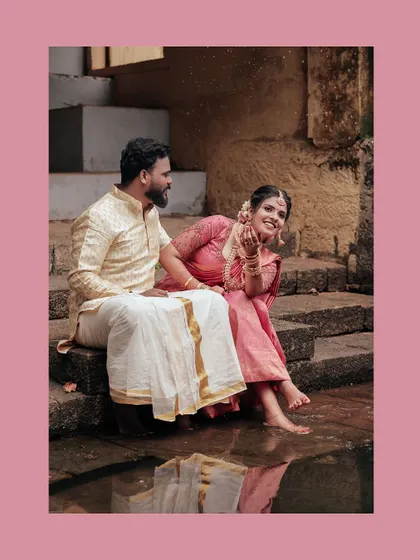 A playful moment with the couple splashing water while sitting on temple steps.
