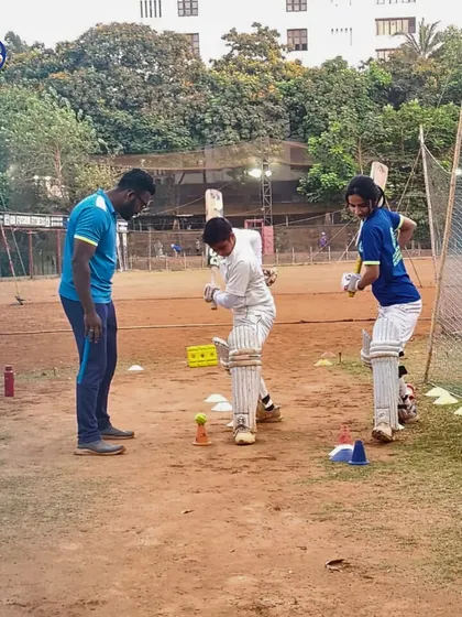 Our coaches provide hands-on skill training to unlock every player's potential. Here, a coach offers personalized feedback on batting technique during a practice session.
