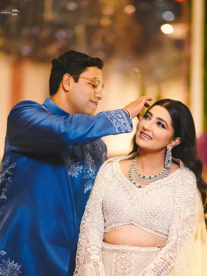 A sweet, candid moment between the couple. The groom gently fixes the bride's hair, a small gesture of love that I always look for.