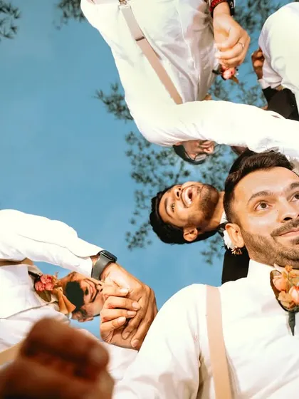 A fun, creative shot of the groom and his groomsmen, taken from the reflection on a glass surface.