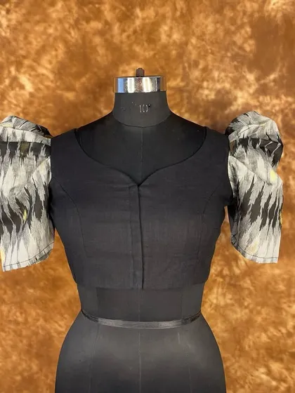 Another look at the classy and bold black puff sleeve blouse. The front-open design with hooks ensures a perfect fit, ready to glam up your saree look for any season.