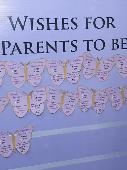 A wish board filled with butterfly-shaped notes for the parents-to-be.