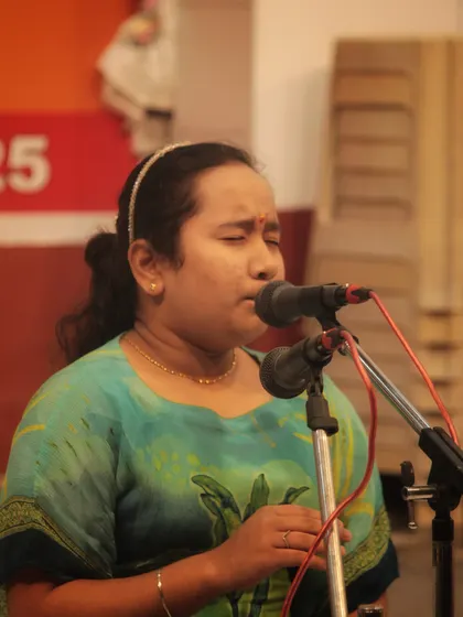 A student deeply focused on her singing during the temple performance.