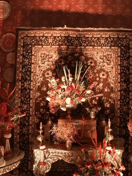 A vintage-inspired setup featuring antique-style clocks, ornate carpets, and lavish red floral arrangements. This design captures a sense of timeless elegance and cultural richness.