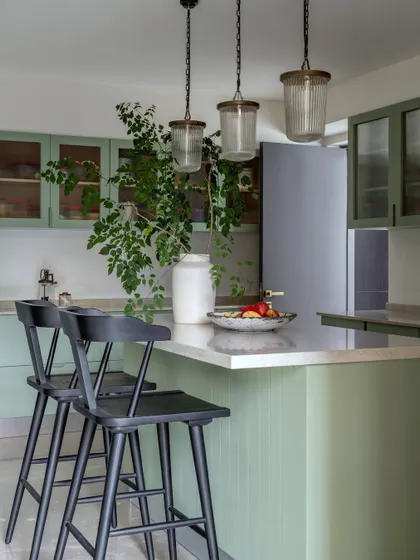 The kitchen in the Rio Home after its remodel. We chose a warm sage green for the cabinets and a large central island to make the space both highly functional and aesthetically pleasing.
