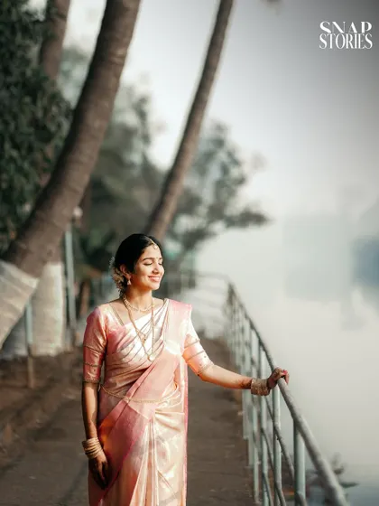 A serene portrait of the bride in a beautiful silk saree, enjoying a quiet moment by the water. We create opportunities for calm, reflective portraits amidst the wedding day buzz.