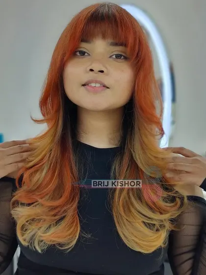 Y2K fashion is back. This creative, funky hair color takes you back in time with its bold orange and blonde patterns.