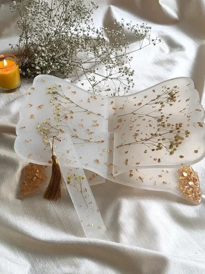 This is a handmade resin holy book stand, or rihal, created with delicate preserved baby's breath flowers and gold details. It’s designed to be a beautiful and functional piece for your sacred space.