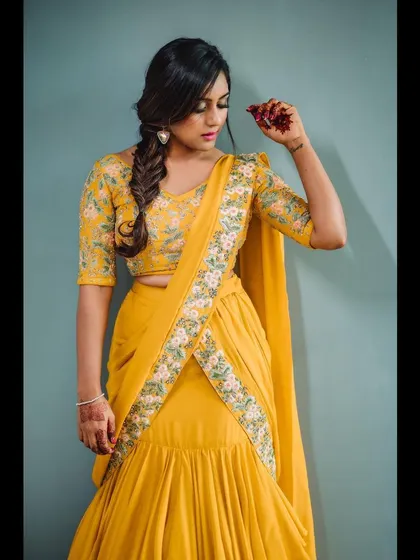A detailed shot of a modern yellow lehenga-saree. This portrait focuses on the embroidered belt and the unique drape of the outfit, ideal for a designer lookbook.