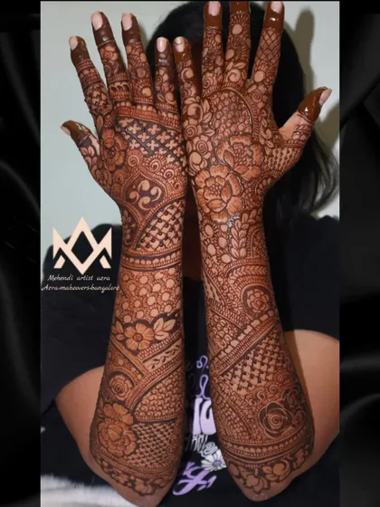 A full view of an intricate bridal design, showcasing the dense patterns that cover the hands and arms completely.