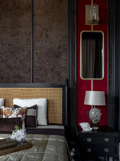 We believe in creating interiors with depth and character. This bedroom features a bold red accent wall paired with dark wood panelling and custom lighting, crafting a space that is intimate, luxurious, and highly personal.