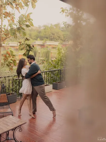 A romantic dance on a balcony, framed by foliage to create a private, intimate feeling.