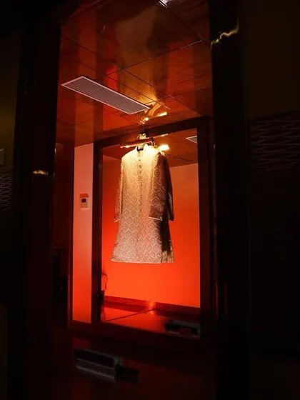 An artistic shot of the groom's sherwani hanging in a room with dramatic red lighting. We find creative ways to photograph every element of the wedding.