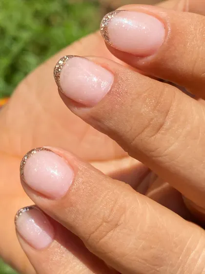 A simple yet glamorous look for short nails. This is a sheer nude overlay with a delicate gold glitter French tip.