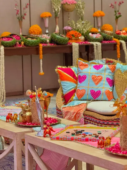 We blended Gujarati and Marwadi aesthetics with Patola prints, gota patti work, heart-themed cushions, and tables laden with marigolds and nostalgic childhood candies.
