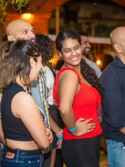 A crowd of smiling faces watching a performance. The supportive atmosphere at La Rumba is one of my favorite things.