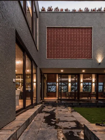 A view of the internal courtyard, which brings natural light and ventilation into the core of the house, featuring a decorative jali screen as an artful accent.