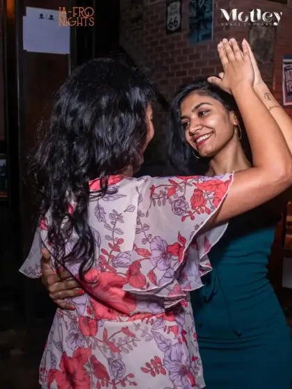 Two dancers sharing a high five and a smile. Our social nights are all about creating a positive and encouraging environment for everyone.