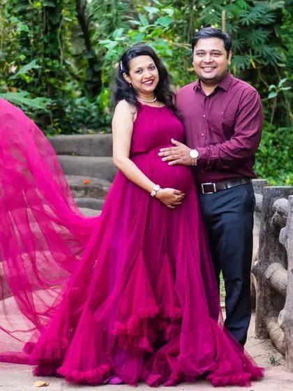 The dramatic, flowing train of this magenta gown makes for a spectacular photo. It adds a fairytale quality to this outdoor maternity portrait on a charming bridge.