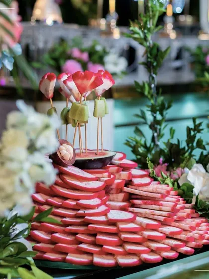 A beautiful display of fresh fruit skewers, artfully arranged amidst flowers. This is a healthy, refreshing, and visually stunning addition to any buffet or grazing table.